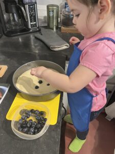 kitchen helper placing blueberries